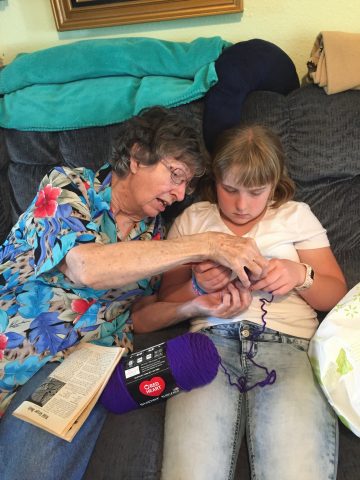 Mrs. Trant teaches Abi to crochet.